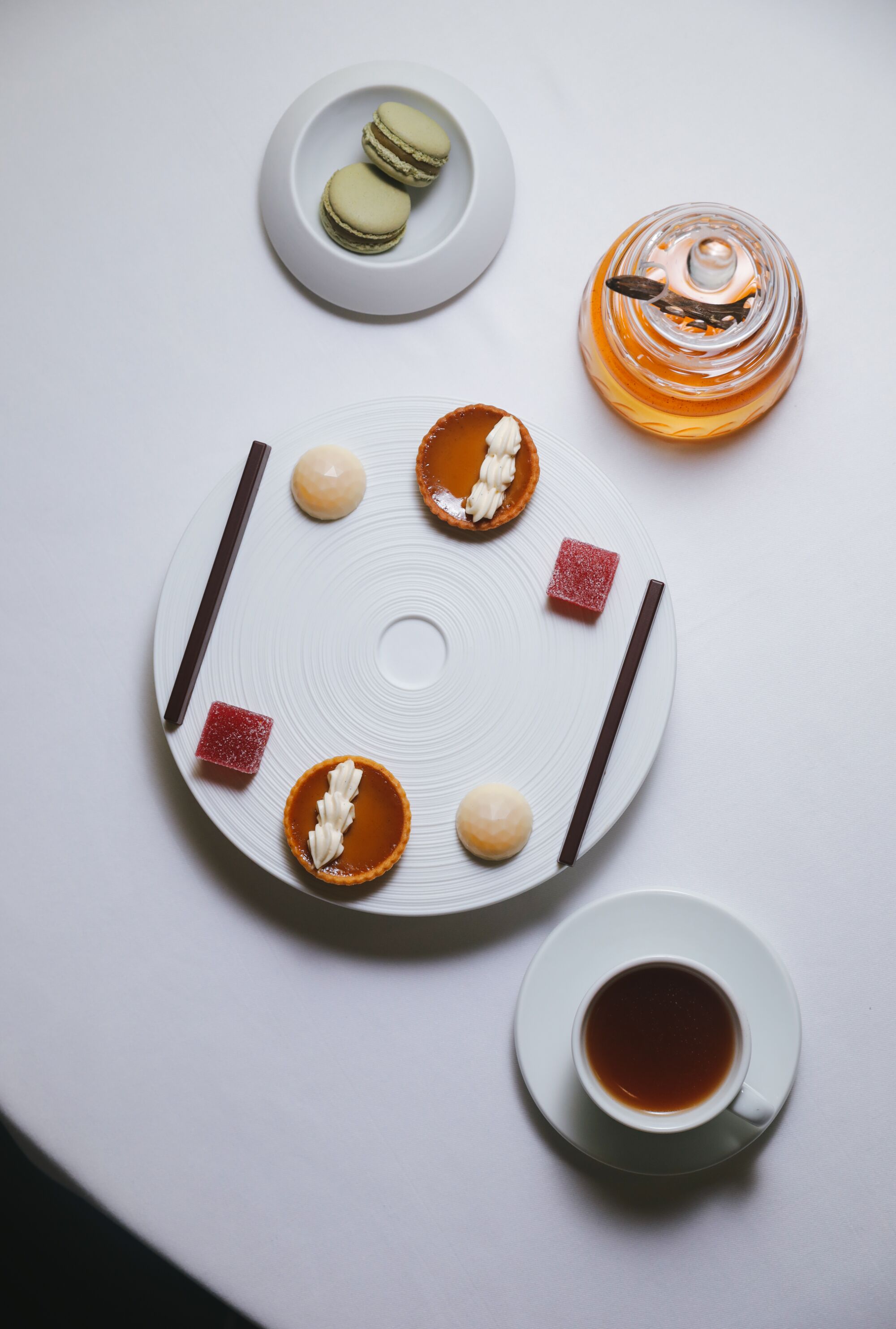 Macarons and a fancy dessert plate with a cup of tea