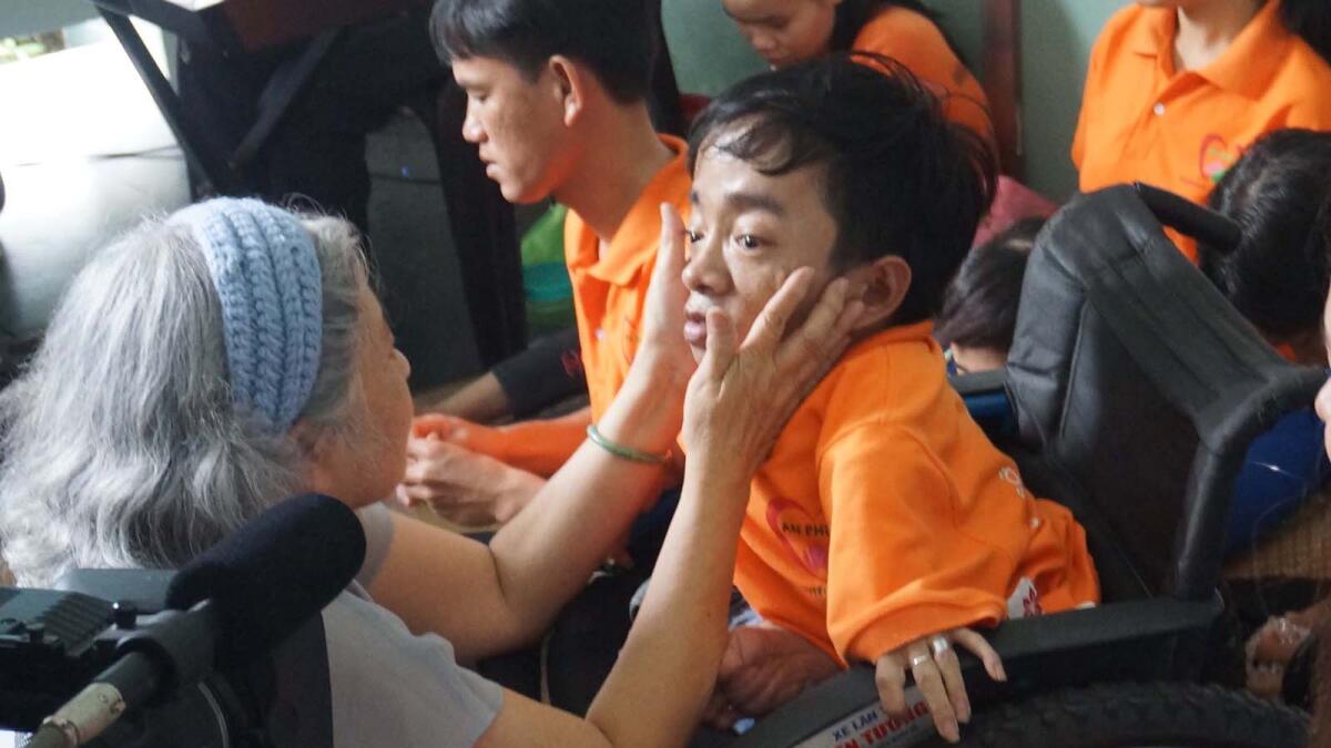 Activist Tran To Nga touches a boy's face