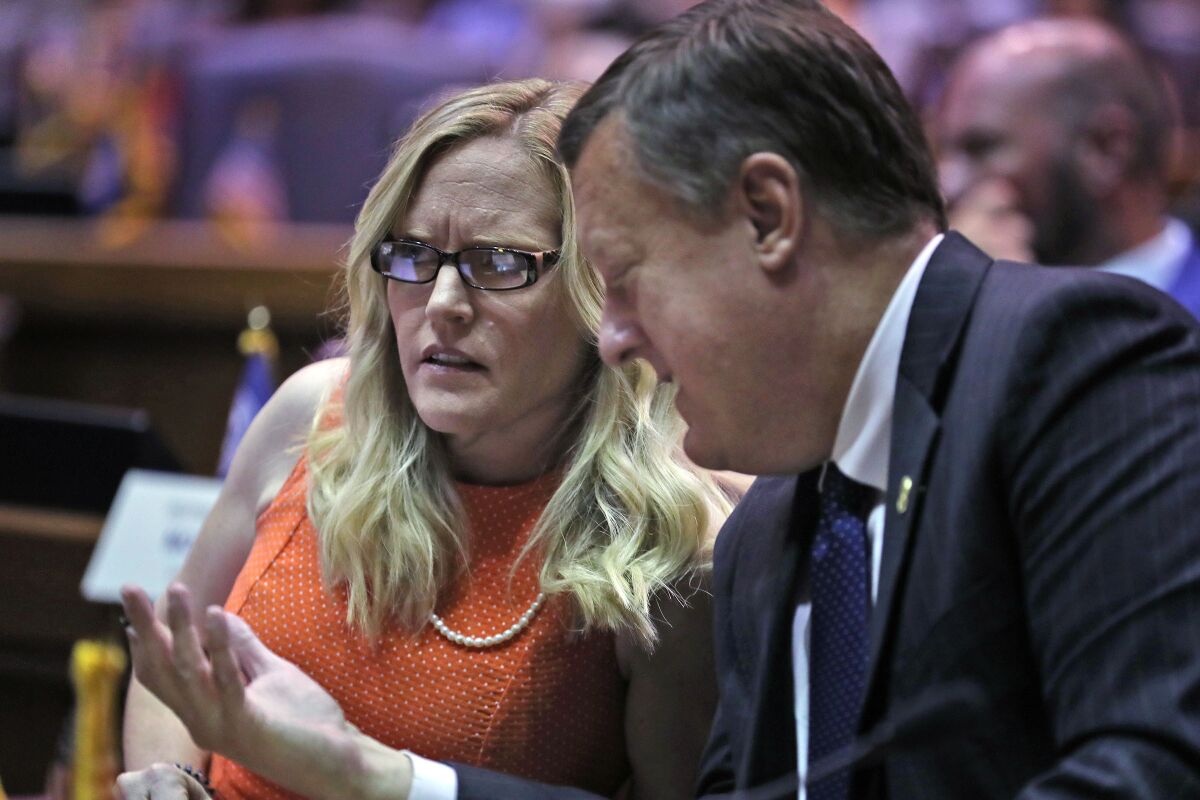FILE - Indiana state Sen. Erin Houchin, R-Salem, left, speaks with Sen. Eric Koch, R-Bedford during a legislative hearing at the Indiana Statehouse in Indianapolis on Aug. 21, 2021. American Dream Federal Action, a super PAC financed by a cryptocurrency CEO, saturated the district with ads promoting Houchin as a “Trump Tough” conservative who would “stop the socialists in Washington.” That push helped secure her win last week in a Republican primary. (Kelly Wilkinson/The Indianapolis Star via AP, File)