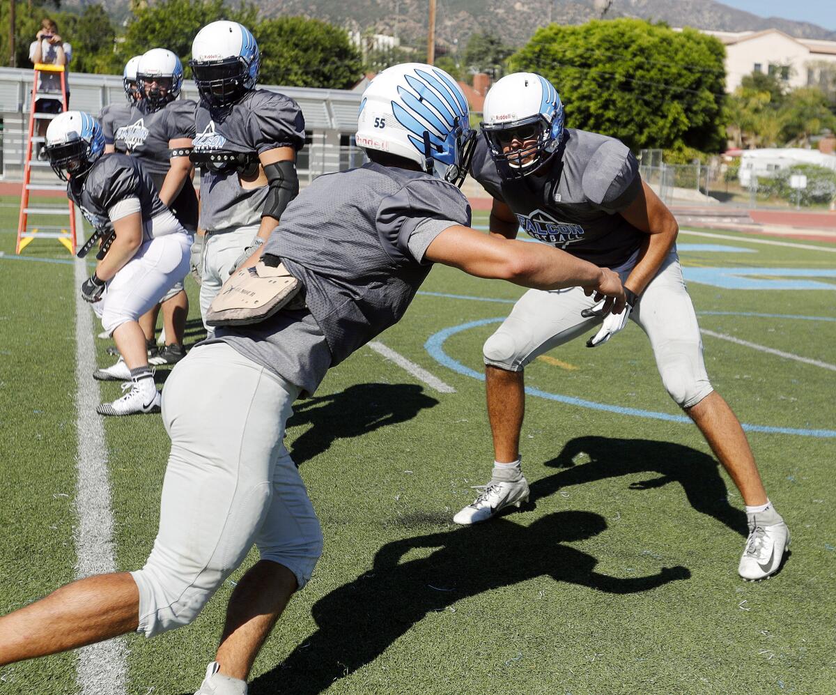Crescenta Valley offensive lineman Chuck Meyer steps back during a blocking drill at a preseason football practice at Crescenta Valley High School on Thursday, August 15, 2019.