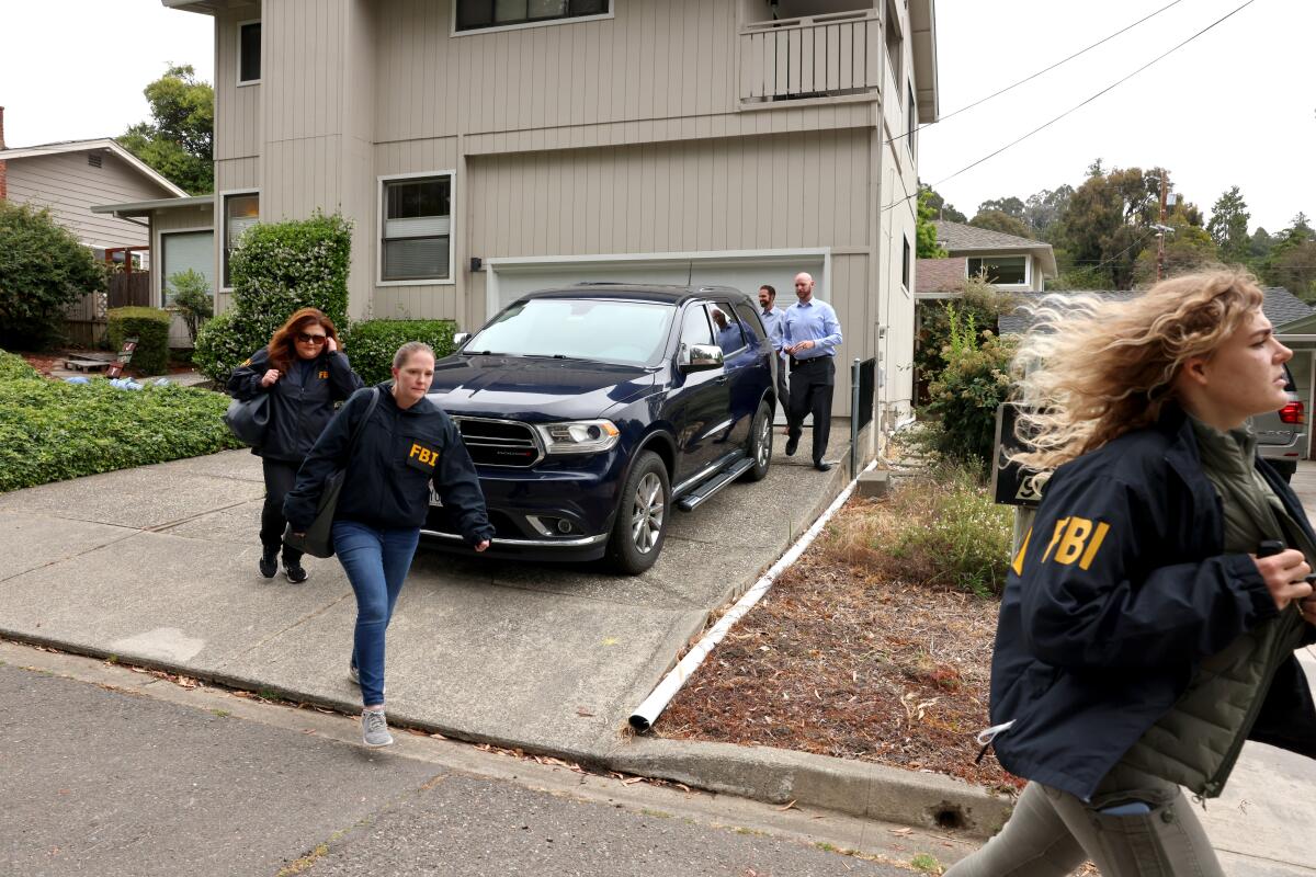 FBI agents exit a home in Oakland.
