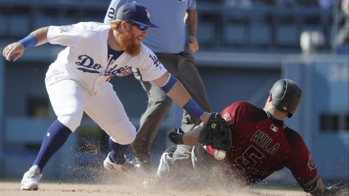 Dodgers third baseman Justin Turner drops the ball as he tries to tag Arizona Diamondbacks catcher Alex Avila on a ninth-inning double on Sunday at Dodger Stadium.