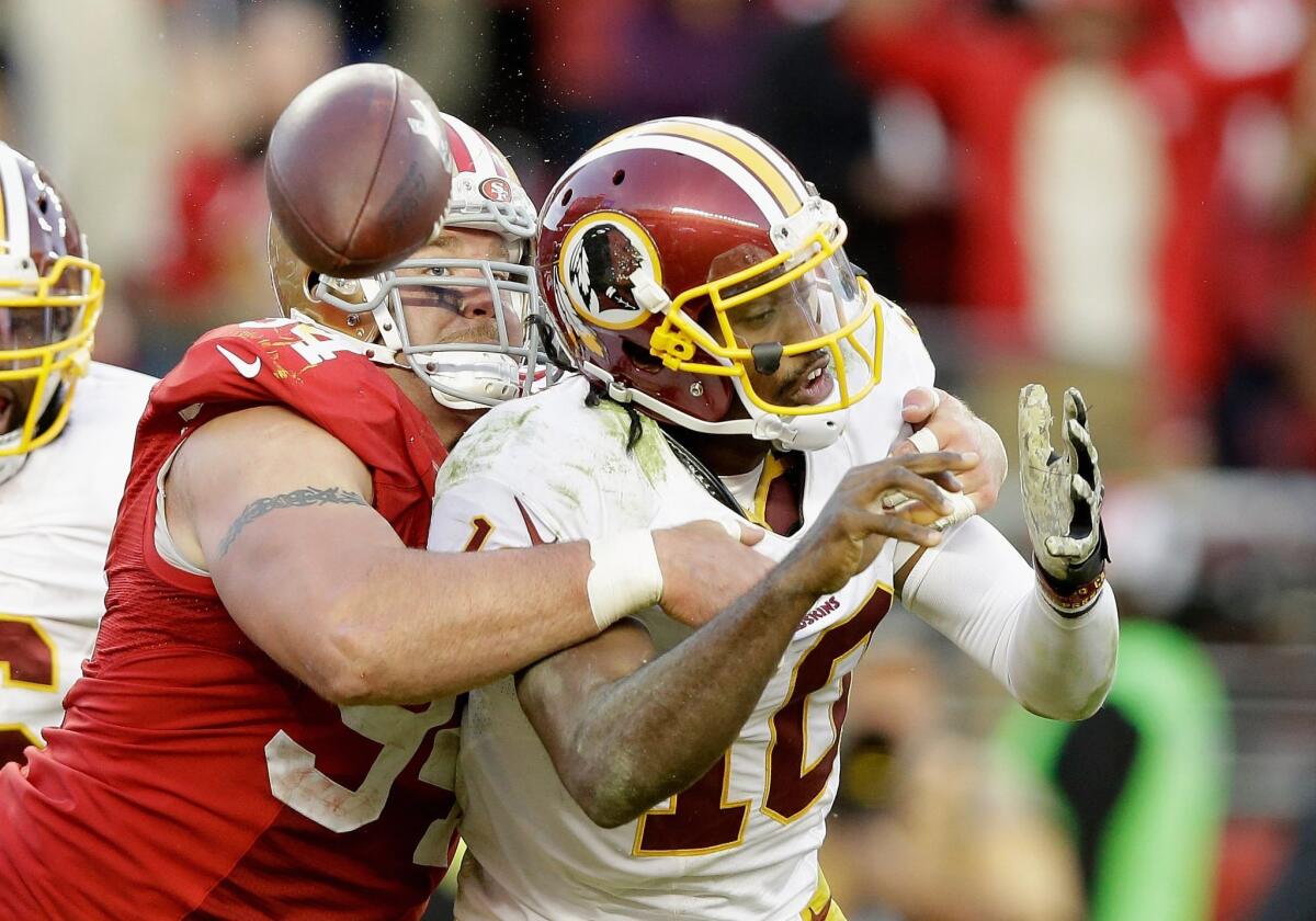 San Francisco's Justin Smith forces a fumble by Washington quarterback Robert Griffin III on Sunday.