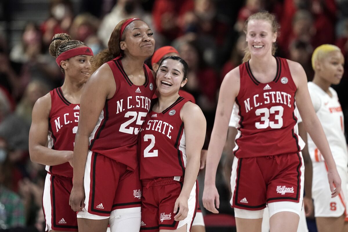 North Carolina State forward Kayla Jones (25) and guard Raina Perez (2) react with center Elissa Cunane (33) during the second half of an NCAA college basketball game against Syracuse in Raleigh, N.C., Sunday, Feb. 20, 2022. (AP Photo/Gerry Broome)
