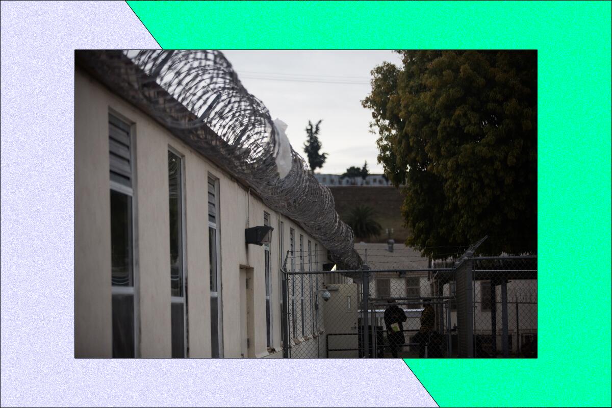 Exterior of a prison with barbed wire lining the top of the wall
