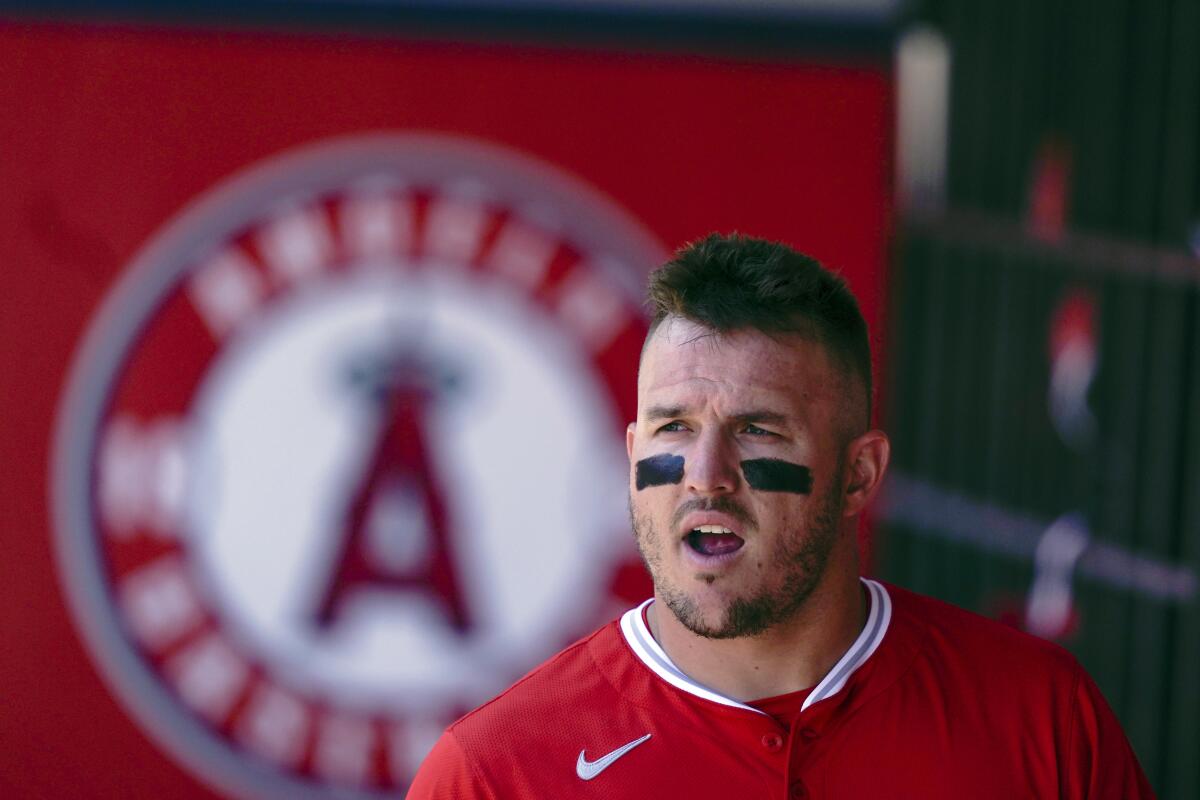 Angels star Mike Trout stands in the dugout during a game.