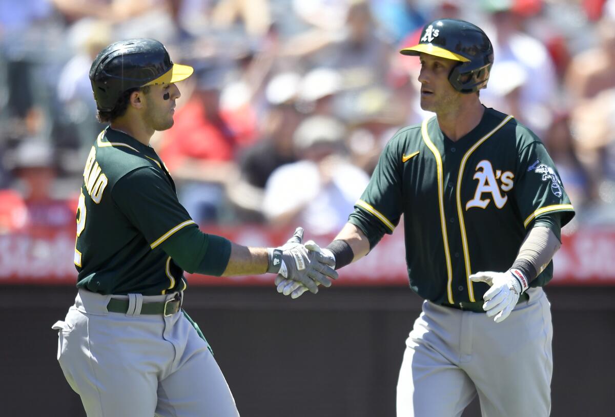 Oakland Athletics' Ramon Laureano congratulates Yan Gomes on his two-run home run in the fourth inning while playing against the Los Angeles Angels in a baseball game Sunday, Aug. 1, 2021, in Anaheim, Calif. (AP Photo/John McCoy)