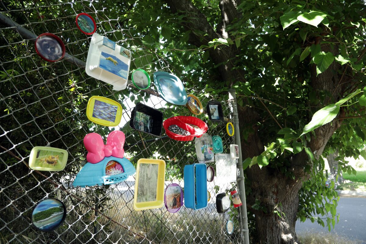 "What Now?" is a photo collage in Woodland Hills by Constance Mallinson, created with plastic litter and photos of endangered species and environments. 