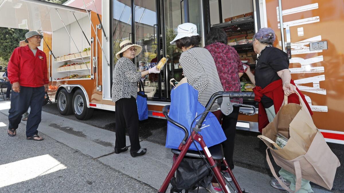 Village Center Apartments senior citizens select fresh, nutritious foods during the Park-It Market launch in Anaheim on Wednesday.