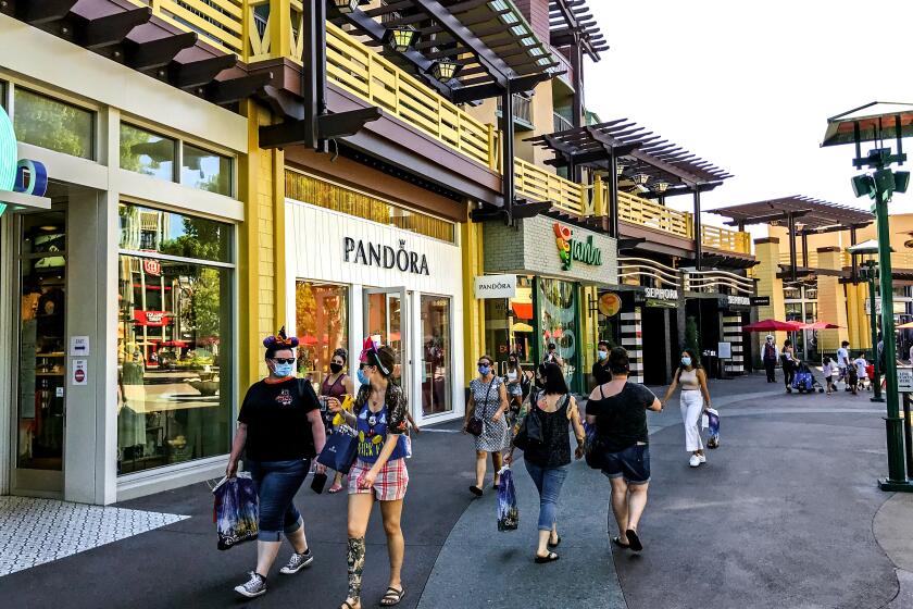 People walk through the Downtown Disney District during a phased reopening, Wednesday, Sept. 30, 2020
