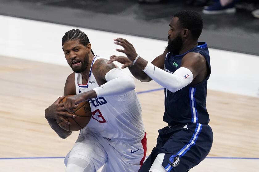 Los Angeles Clippers guard Paul George (13) fights to the basket against Dallas Mavericks' Tim Hardaway Jr, right, in the first half in Game 3 of an NBA basketball first-round playoff series in Dallas, Friday, May 28, 2021. (AP Photo/Tony Gutierrez)