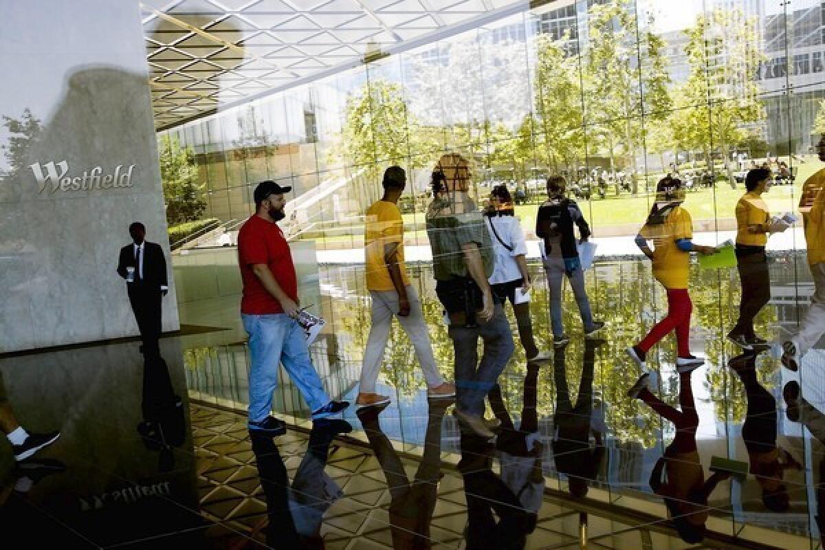 Refund LA union activists visit the lobby of Westfield in Century Plaza Towers in Los Angeles. They are targeting the mall operator as what they say is an example of big businesses that pay too little in taxes under Proposition 13.