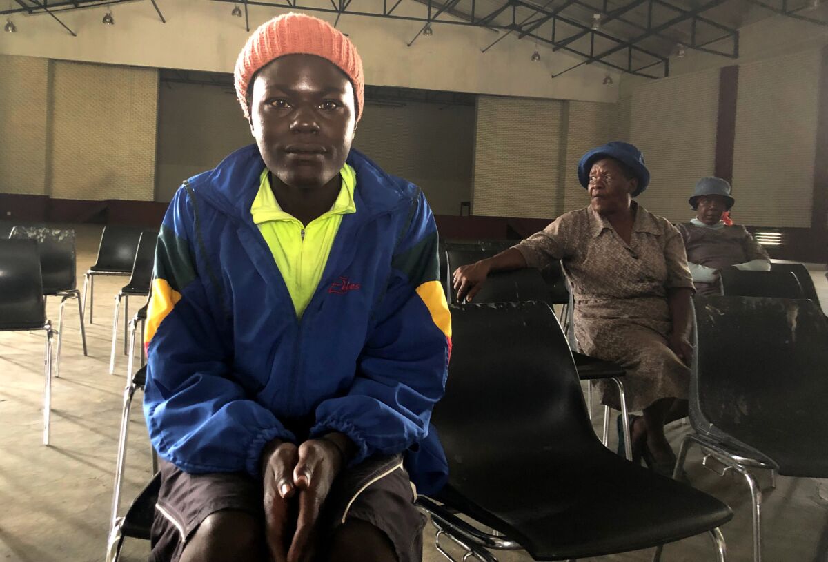 James Mashakeni, left, and Grace Pitse, center, attend a meeting in a community hall in Brits, South Africa, about drug addiction.