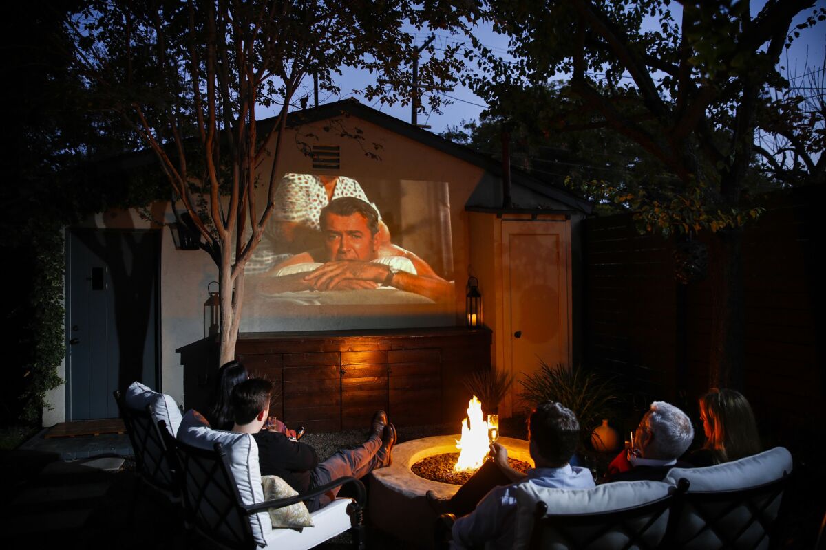 Chad Rothman and Michael Moore enjoy movie night in the backyard of their home in the Brookside neighborhood, just south of Hancock Park.