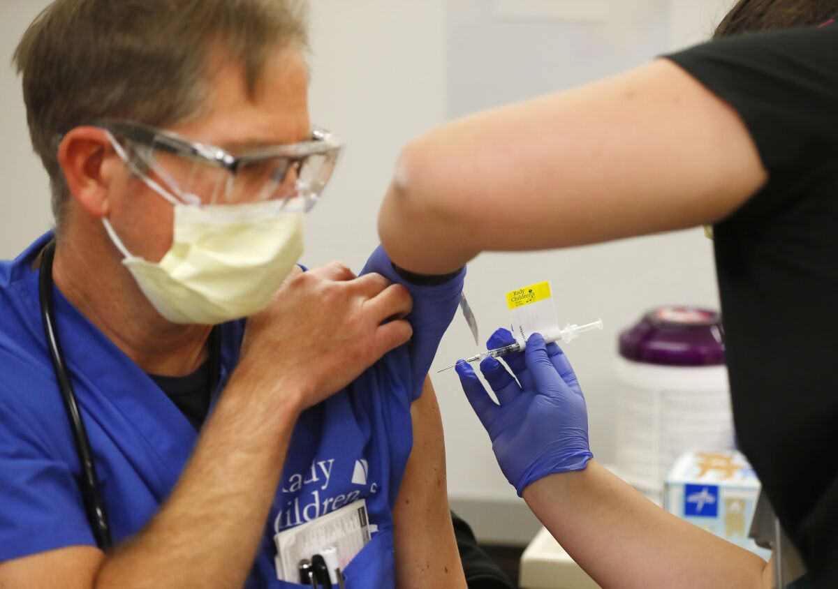 Nurse practitioner Dan Jacobson gets a Pfizer-BioNTech COVID-19 Vaccine shot.