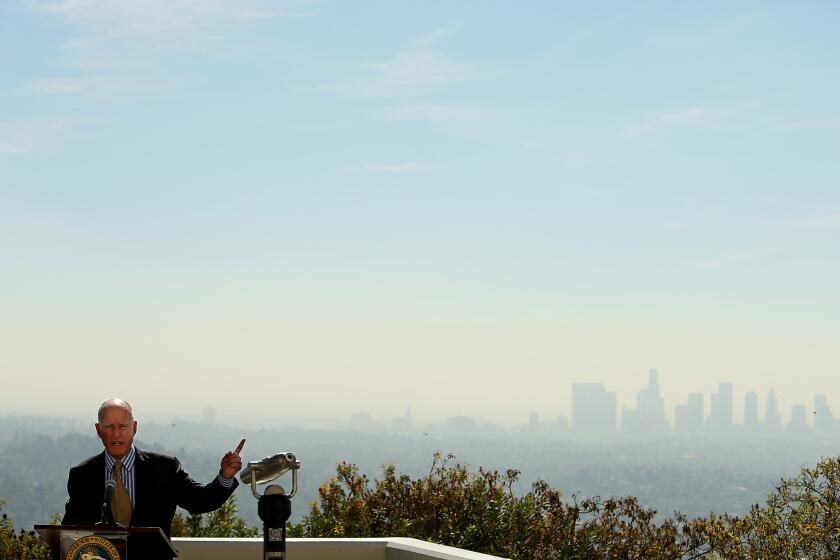 Gov. Jerry Brown, shown at the Griffith Observatory last year, signed new climate legislation in a Los Angeles park on Thursday.