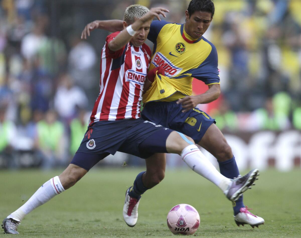 Chivas' Adolfo Bautista, left, fights for the ball with America's Juan Valenzuela during a Mexican soccer league game at the Azteca stadium in Mexico City, Sunday, Oct. 24, 2010. The game ended tied 0-0.