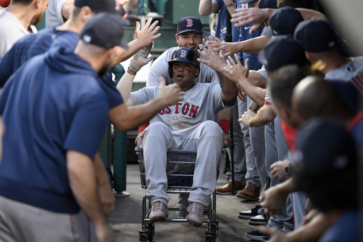 Boston Red Sox' Rafael Devers, front, celebrates his two-run home run in the dugout during the ninth inning of a baseball game against the Washington Nationals, Sunday, Oct. 3, 2021, in Washington. The Red Sox won 7-5. (AP Photo/Nick Wass)