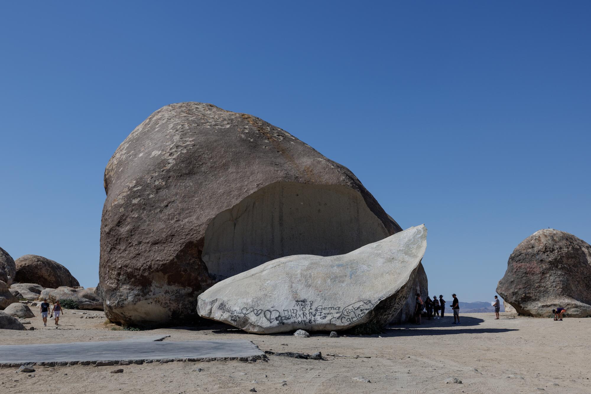 People dot the sand around Giant Rock, a seven story boulder in the Mojave Desert.