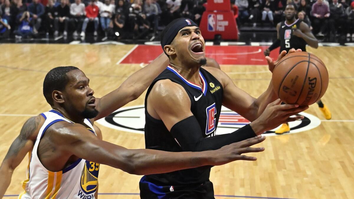 Clippers forward Tobias Harris, right, drives for a layup against Golden State Warriors forward Kevin Durant during the second half on Jan. 18, 2019, at Staples Center.