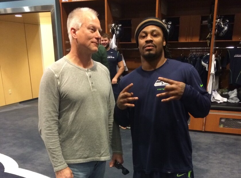ESPN "SportsCenter" anchor Kenny Mayne, left, stands alongside former Seattle Seahawks running back Marshawn Lynch