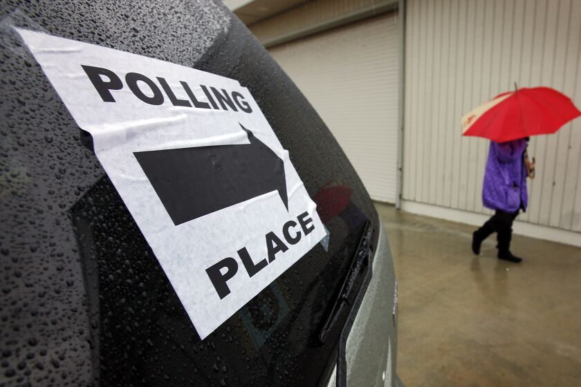 VENICE, CA - MAY 17, 2011: A voter uses her umbrella in the rain after voting at the LA County Lifeguard Headquarters polling location on Ocean Front Walk in Venice on a cold and wet Tuesday morning as few voters turned out to vote in the race to elect a successor for Representative Jane Harman and a LAUSD board member. (Al Seib / Los Angeles Times)