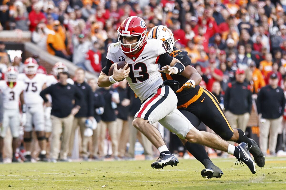 Georgia quarterback Stetson Bennett runs for a touchdown as he's chased by Tennessee linebacker Aaron Beasley.