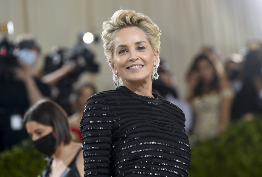 A woman with short blond hair wearing a sparkly black dress