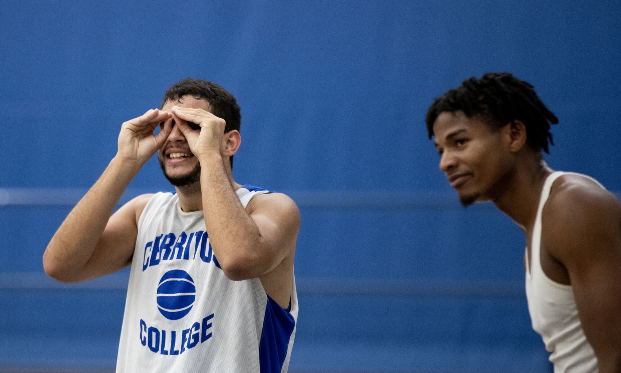 Kade West uses sign language while standing next to Cerritos College teammate Malik Johnson.