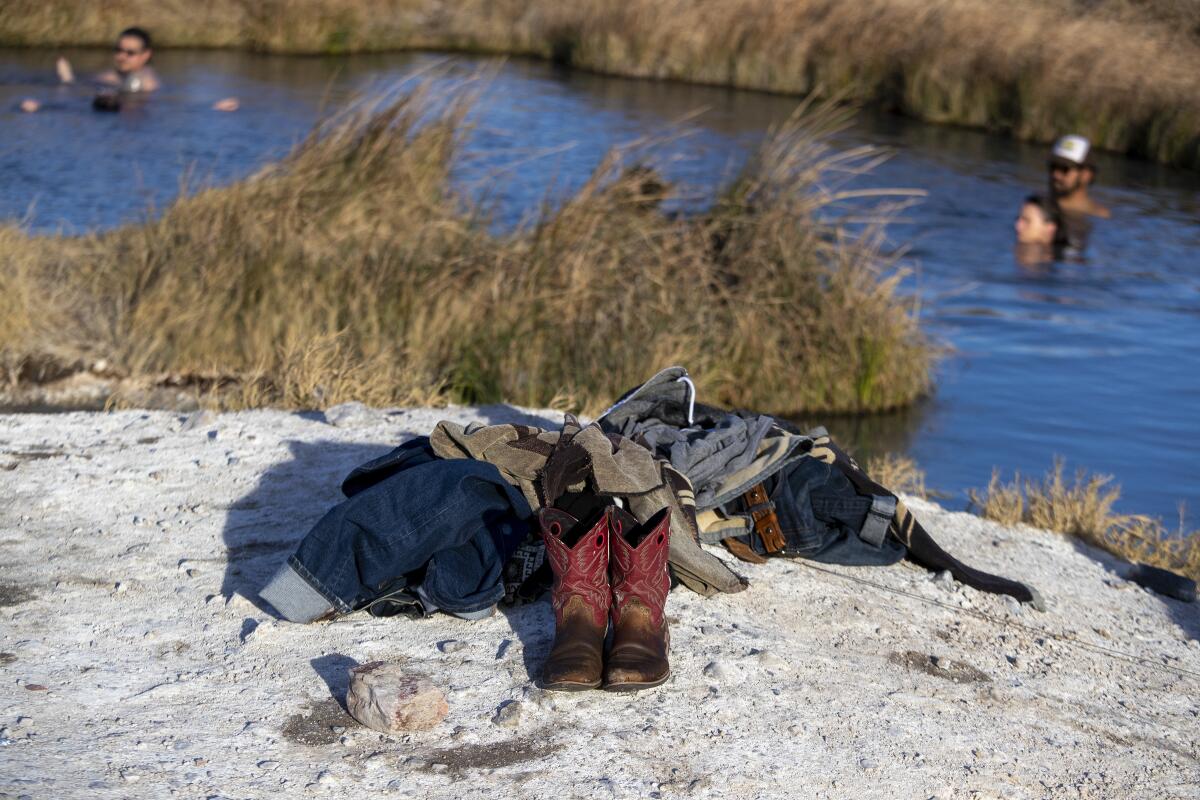 Boots and a pile of clothing left on the ground by bathers enjoying  a hot spring in Tecopa, Calif.