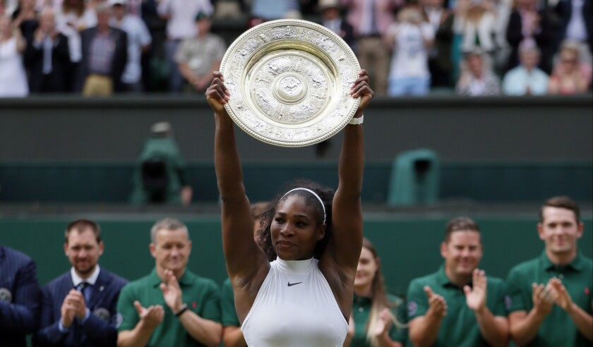 erena Williams holds up the trophy after winning the women's singles final against Angelique Kerber in the championship match at Wimbledon.