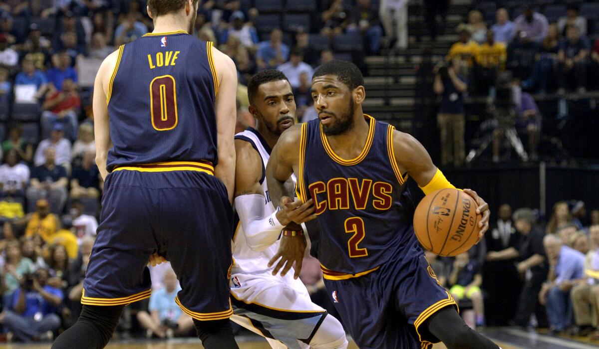 Cavaliers point guard Kyrie Irving uses a screen by forward Kevin Love to get past Grizzlies point guard Mike Conley during their game Wednesday night in Memphis.