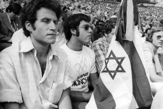 Israelis with a black crepe covered Israeli flag, photographed in the Munich Olympic stadium, Sept. 6, 1972, during the memorial service for the eleven murdered Israeli team members. A crowd of 80,000 filled the stadium for the service. (AP Photo)