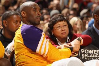 Kobe Bryant #24 of the Los Angeles Lakers has his wrist massaged by the Lakers' Director of Physical Therapy, Dr. Judy Seto, 