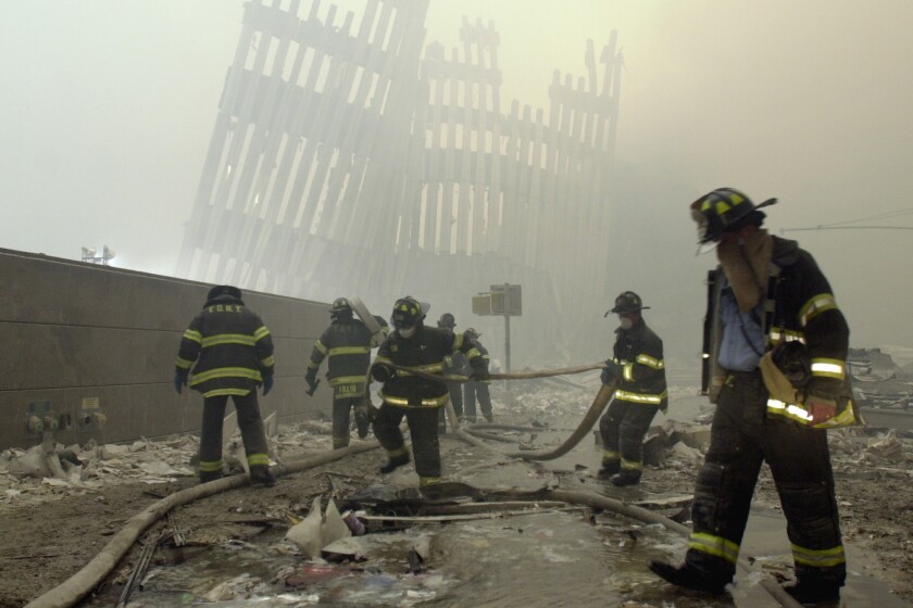 Firefighters work at the World Trade Center towers after the 9/11 terrorist attack in New York in 2001. 