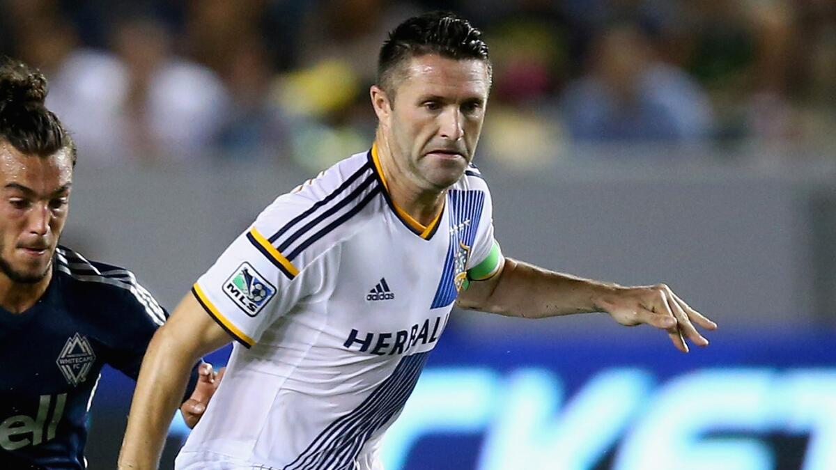 Galaxy forward Robbie Keane is pursued by Russell Teibert of Vancouver during the second half of a game on Aug. 23.
