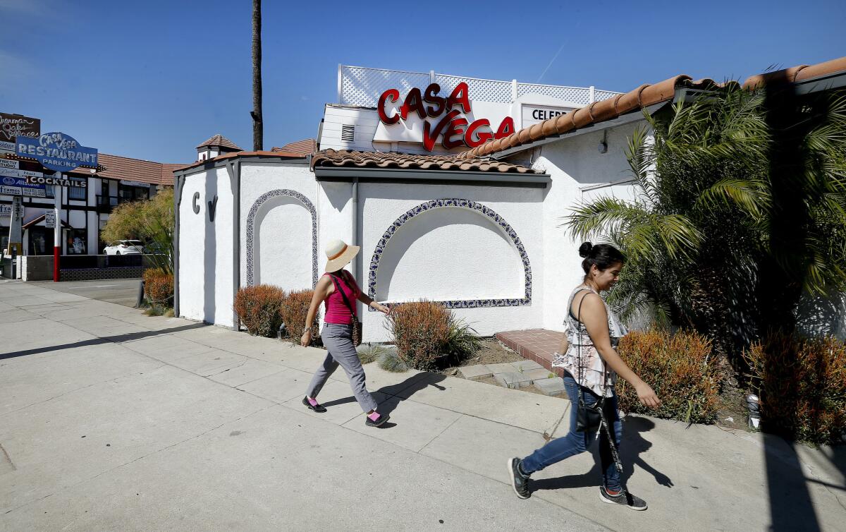 Two women walk past Casa Vega, a Mexican restaurant.