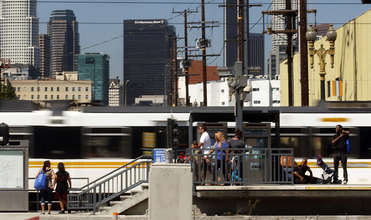 Metro Blue Line cars zip past a station near the intersection of Washington Boulevard and Flower Street, where the Blue Line converges with the Expo Line.