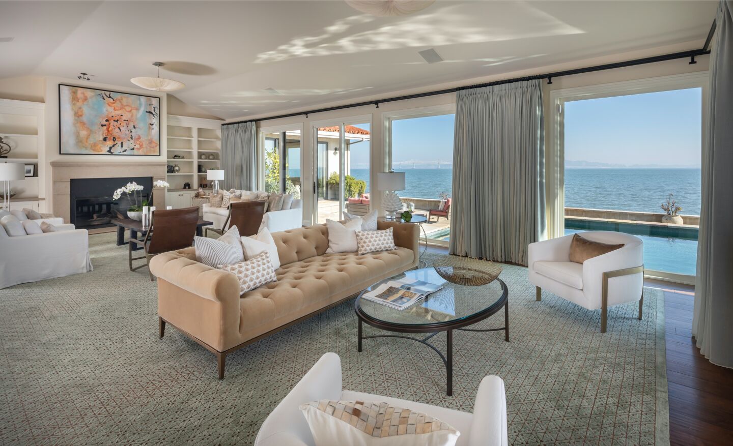The great room with furniture and windows overlooking the bay.