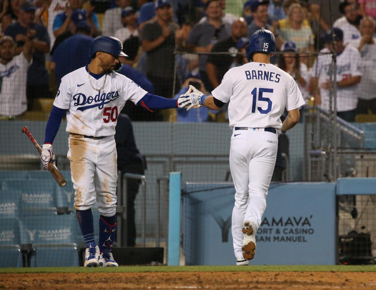 Mookie Betts slaps the hand of Austin Barnes at Dodger Stadium.