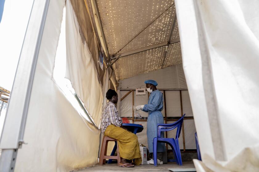 FILE - A health worker attends to a mpox patient, at a treatment centre in Munigi, eastern Congo, Monday, Aug. 19, 2024. (AP Photo/Moses Sawasawa, File)