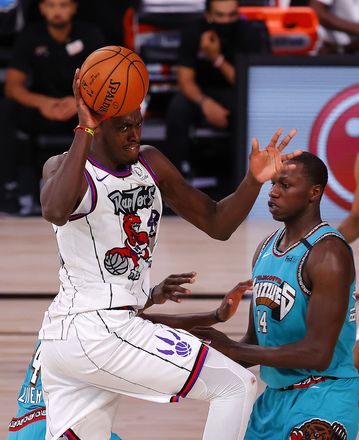 Toronto Raptors' Pascal Siakam, left, is charged with an offensive foul against Memphis Grizzlies' Gorgui Dieng, right, during the second quarter of an NBA basketball game Sunday, Aug. 9, 2020, in Lake Buena Vista, Fla. (Kevin C. Cox/Pool Photo via AP)