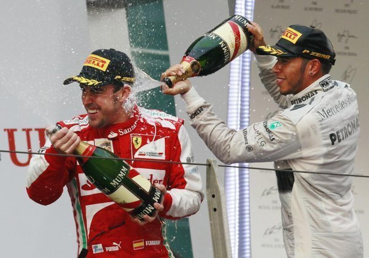Chinese Grand Prix winner Fernando Alonso is sprayed with champagne by Lewis Hamilton, who took third, during the awards ceremony in Shanghai.