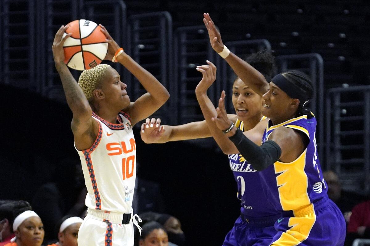 Connecticut Sun's Courtney Williams tries to pass while under pressure from Sparks' Olivia Nelson-Ododa and Brittney Sykes.