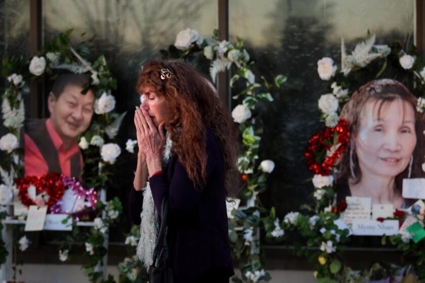 MONTEREY PARK, CA - JANUARY 26, 2023 - - Adelle Castro, 68, of Temple City, cries at the memorial for 11 people who died in a mass shooting during Lunar New Year celebrations outside the Star Ballroom Dance Studio in Monterey Park on January 26, 2023. "They were my family," said Castro who used to dance at the ballroom. "They introduced me to their culture and they were my family. I can't believe it. It's beyond understanding," Castro concluded. (Genaro Molina / Los Angeles Times)
