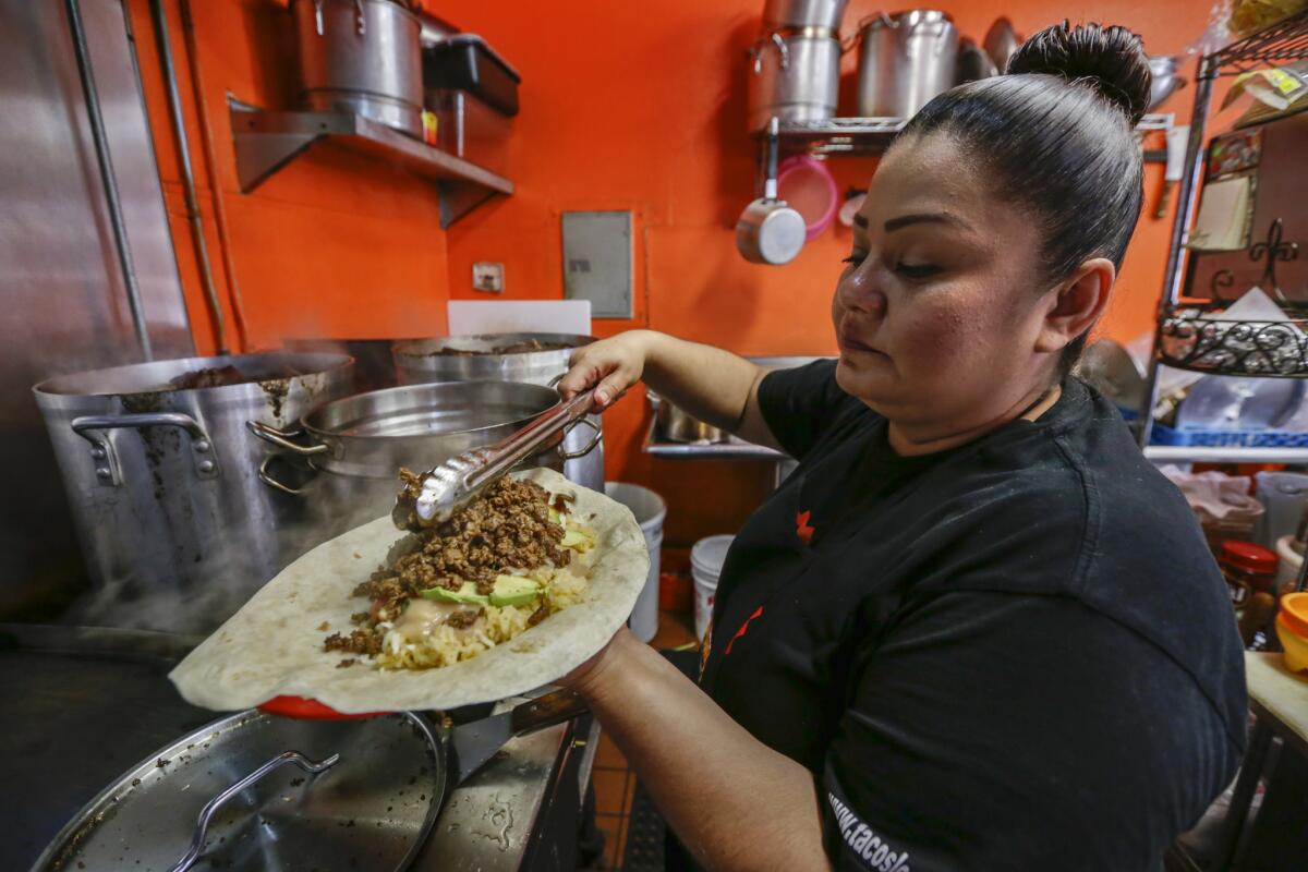 Jackie Gallegos prepares a Pablo Escobar burrito at Tacos Los Desvelados, a narco-themed taqueria in Maywood.