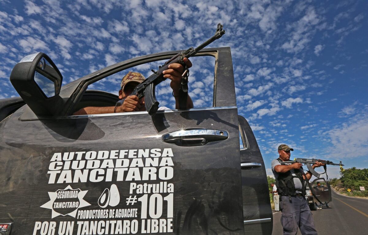 Members of a self-defense group hold a position on a road near the town of Nueva Italia, east of the key city of Apatzingan in the Mexican state of Michoacan.