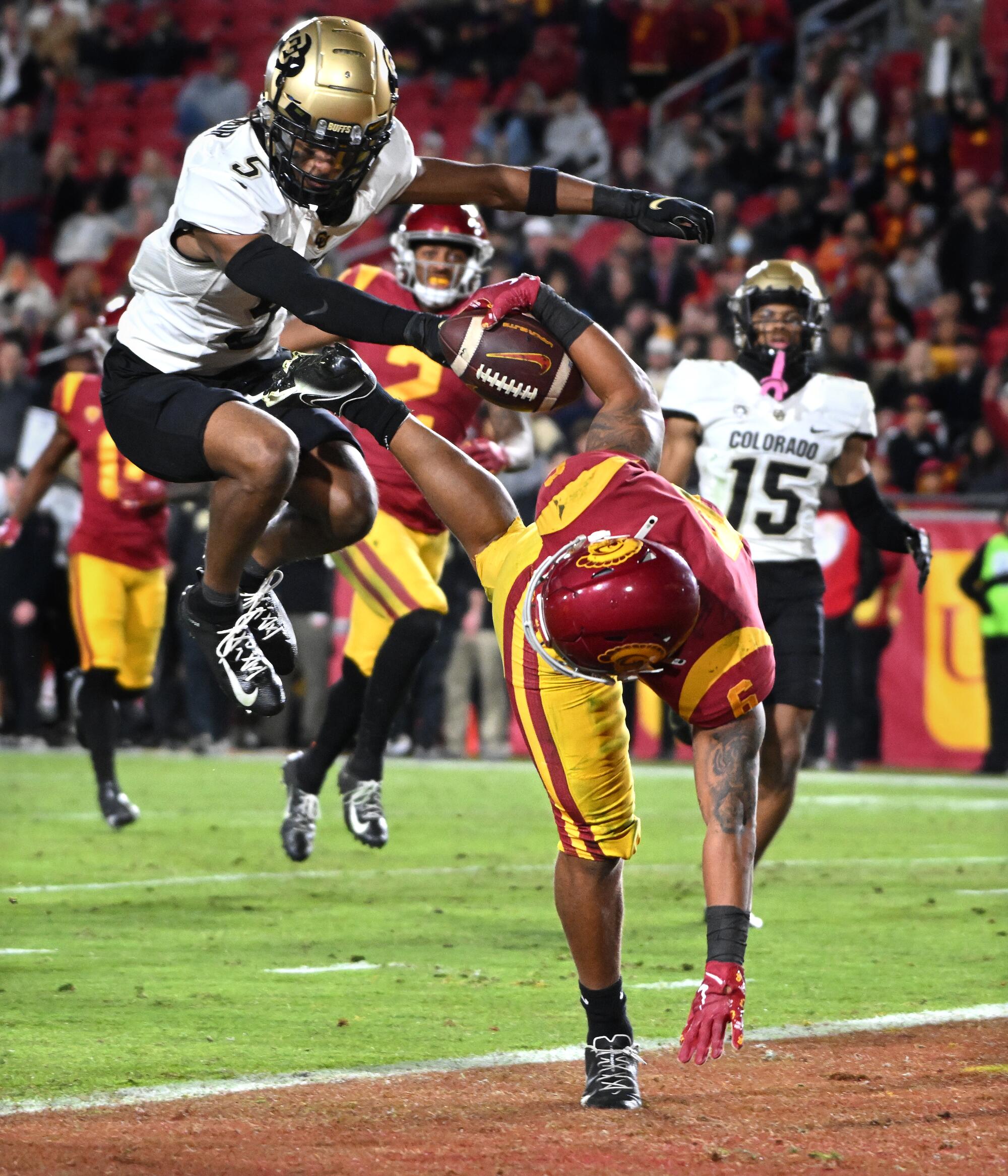 USC running back Austin Jones leaps into the end zone for a touchdown in front of Colorado safety Tyrin Taylor.