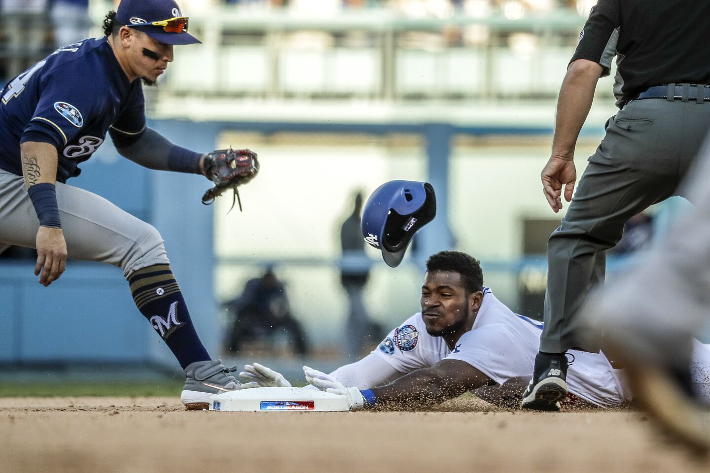 Dodgers Yasiel Puig slides safely into second base with an eighth inning double as Brewers second baseman Hernan Perez is late with the tag.