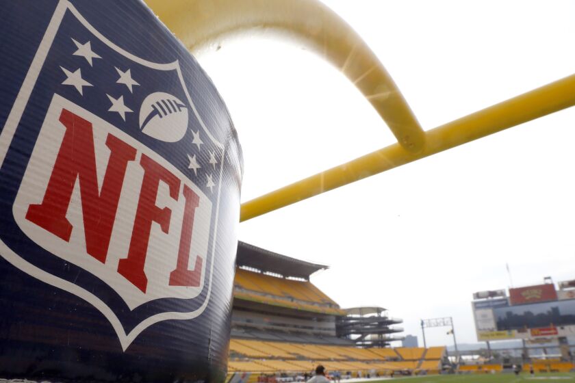 The NFL shield logo is displayed on a field goal post at Heinz Field in September 2013. A judge has approved a multimillion-dollar preliminary settlement offer between the NFL and lawyers for the more than 4,500 former players seeking damages for concussion-related injuries.
